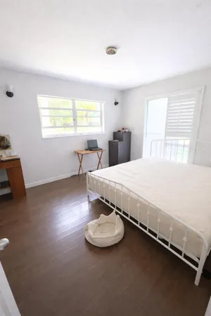 a large bed sitting in a bedroom next to a window