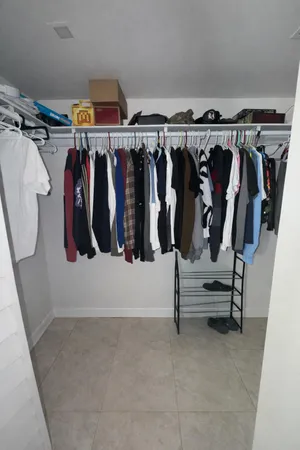 a view of walk in closet with clothes and shoes