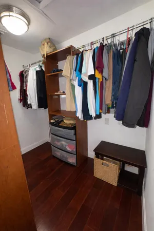 a view of walk in closet with clothes and shoes