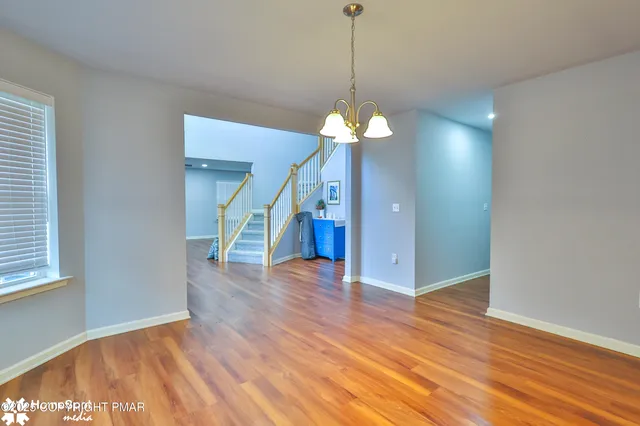 a view of a room with wooden floor windows and a chandelier