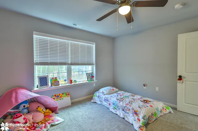 a bedroom with a bed table and window