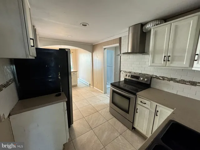 a kitchen with granite countertop a sink stove and cabinets