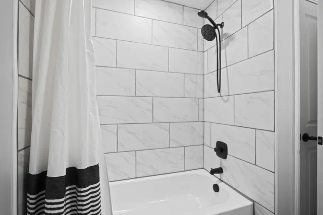 a bathroom with a bathtub and shower