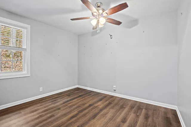 an empty room with a window and a fan