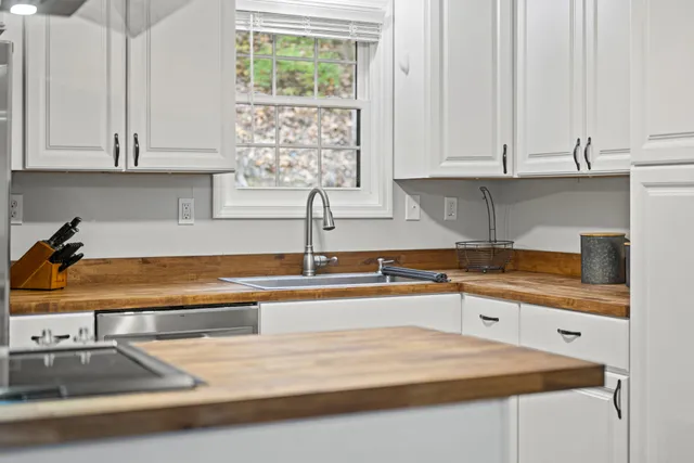 a kitchen with granite countertop a sink a stove and cabinets