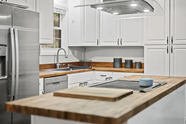a kitchen with stainless steel appliances granite countertop a sink and a refrigerator