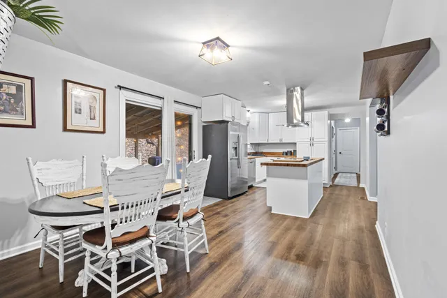 a kitchen with a table chairs refrigerator and microwave