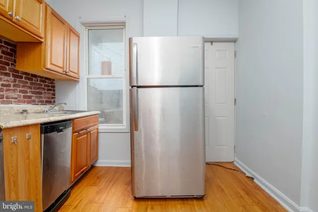 a kitchen with stainless steel appliances granite countertop a refrigerator a sink and a stove