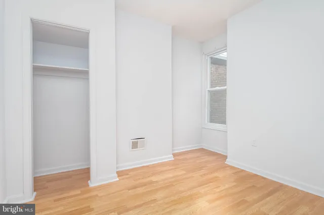 a view of an empty room with wooden floor