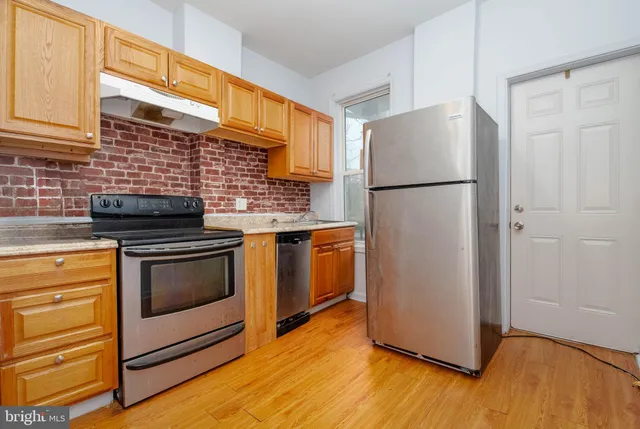 a kitchen with a refrigerator stove and wooden cabinets