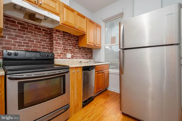 a kitchen with stainless steel appliances granite countertop a stove a refrigerator and a refrigerator