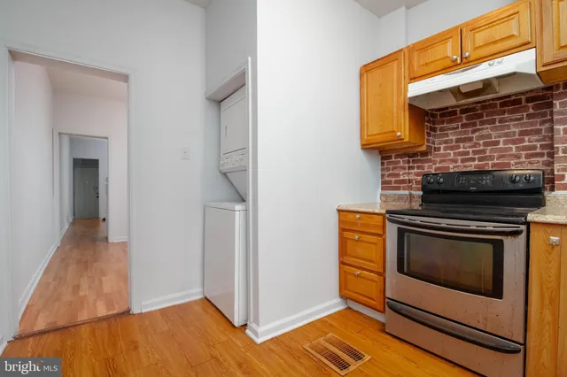 a kitchen with stainless steel appliances wooden floor sink and wooden cabinets