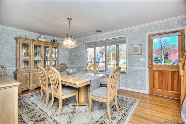 a dining room with furniture a chandelier and wooden floor