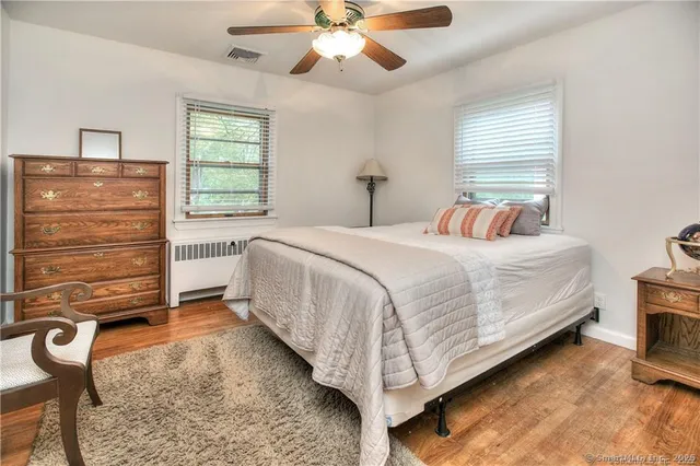 a bedroom with a bed and a ceiling fan