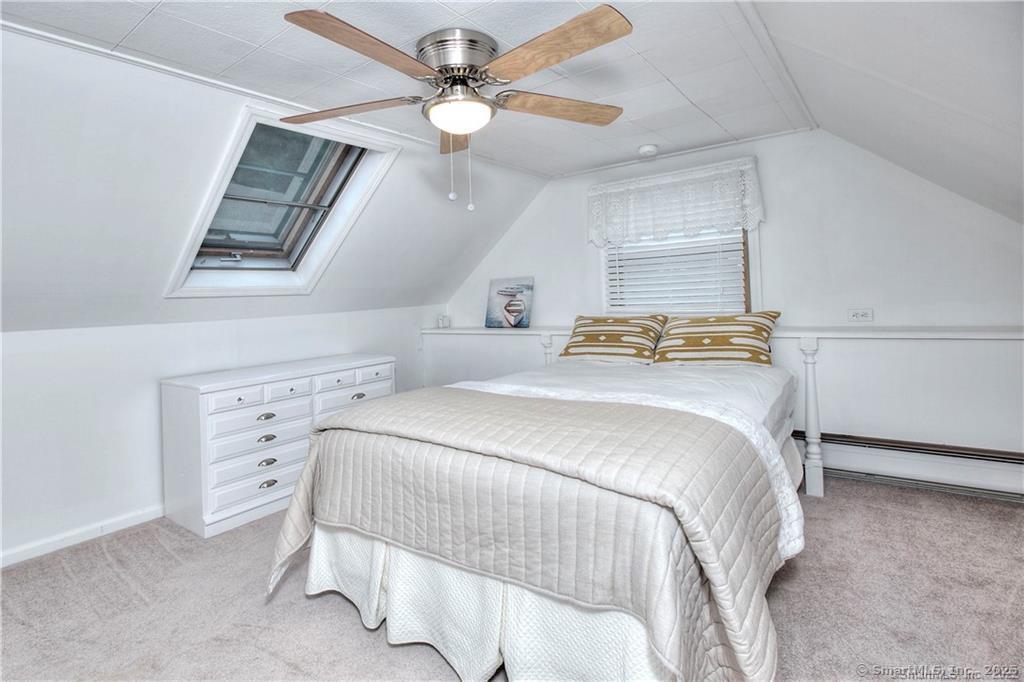 151 Sasapequan Road Fairfield, CT 06824 - Photo 17 of 25 a bedroom with a bed and a chandelier