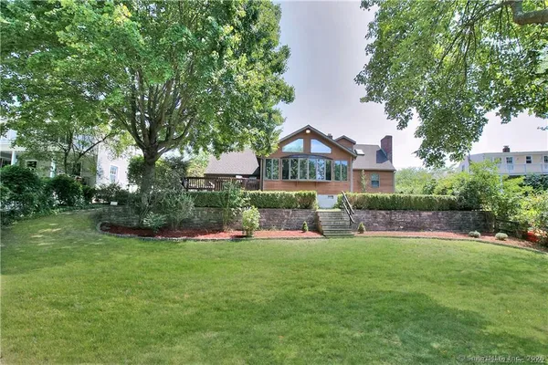 a view of house with garden and tall trees