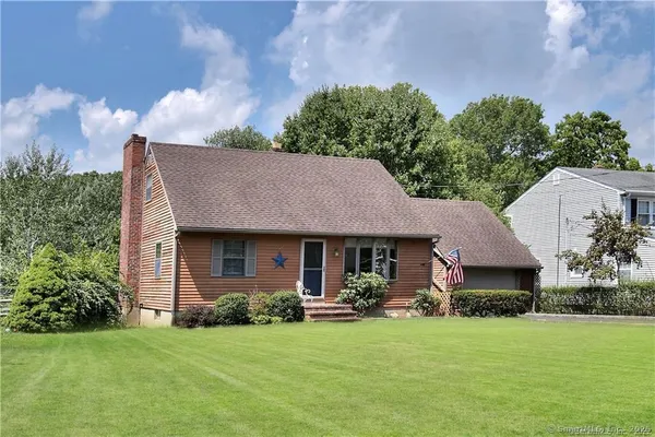 a front view of a house with a garden and yard