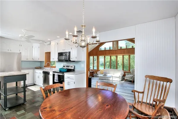a living room with kitchen island furniture and a chandelier