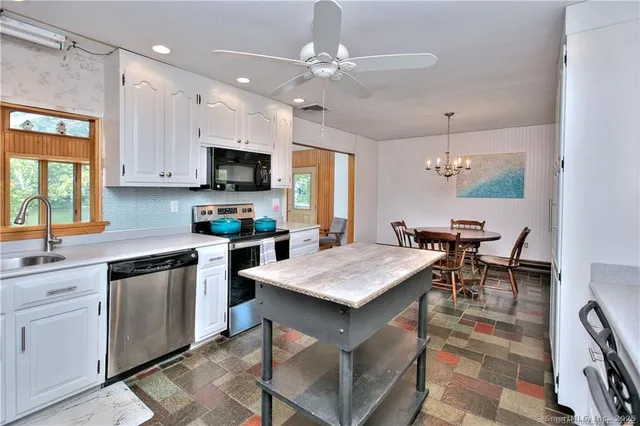 a kitchen with a table chairs sink and cabinets