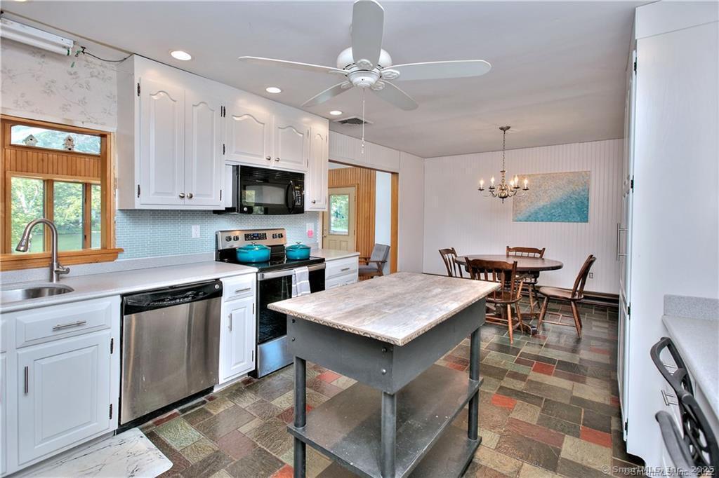 151 Sasapequan Road Fairfield, CT 06824 - Photo 9 of 25 a kitchen with a table chairs sink and cabinets