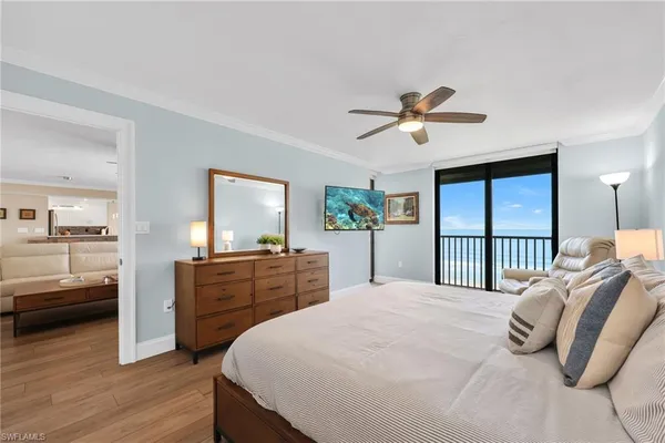 a bedroom with a bed couch and a ceiling fan