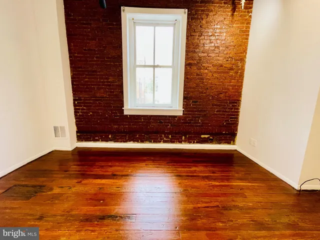 a view of a room with wooden floor and a window