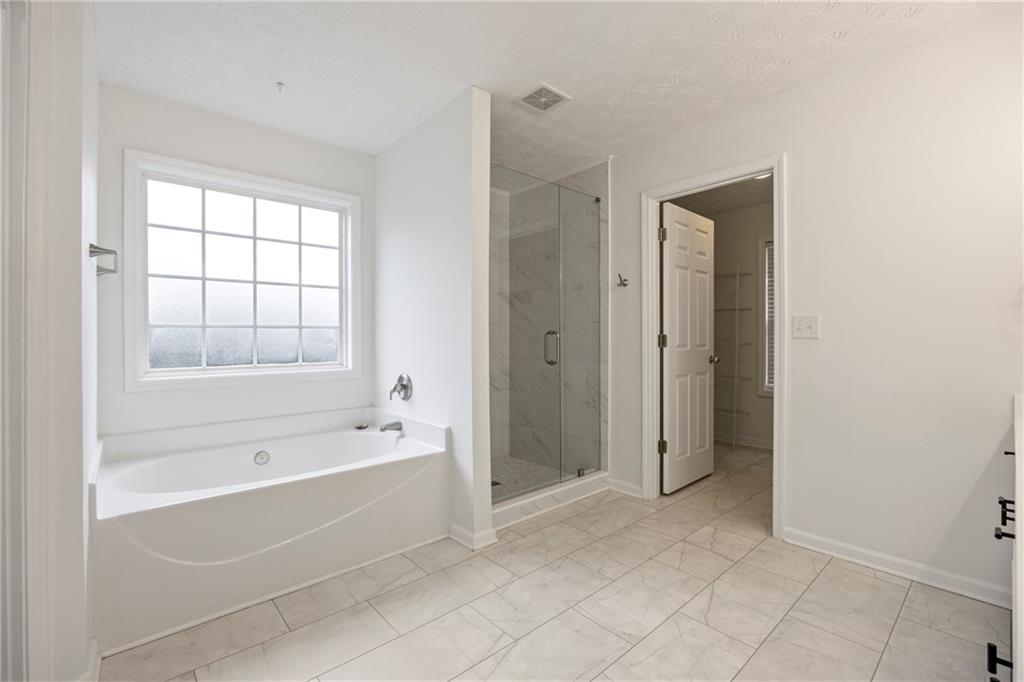3768 North Sharon Church Road Loganville, GA 30052 - Photo 24 of 58 a spacious bathroom with a bathtub and a shower