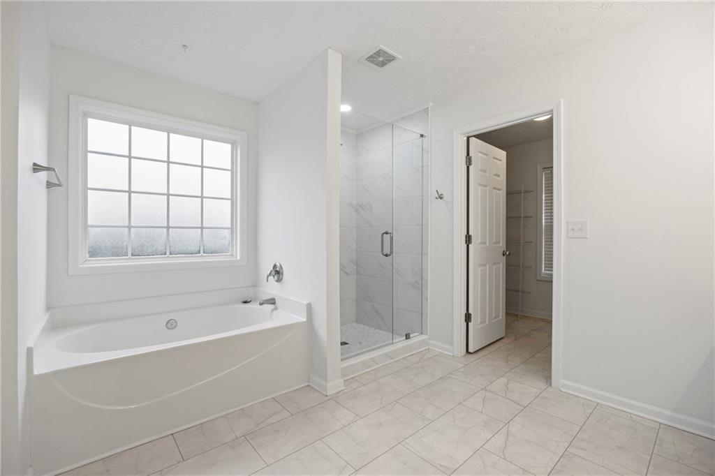 3768 North Sharon Church Road Loganville, GA 30052 - Photo 27 of 58 a spacious bathroom with a bathtub and a shower