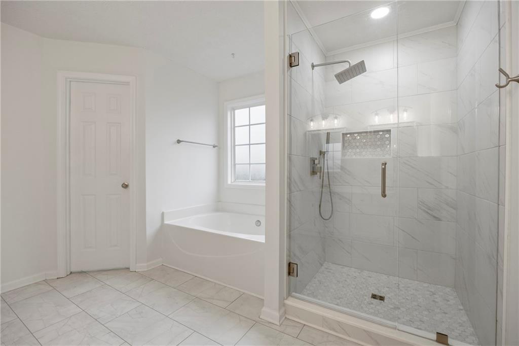 3768 North Sharon Church Road Loganville, GA 30052 - Photo 28 of 58 a bathroom with a bathtub and a shower