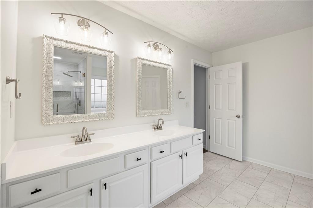 3768 North Sharon Church Road Loganville, GA 30052 - Photo 29 of 58 a bathroom with a double vanity sink and a mirror