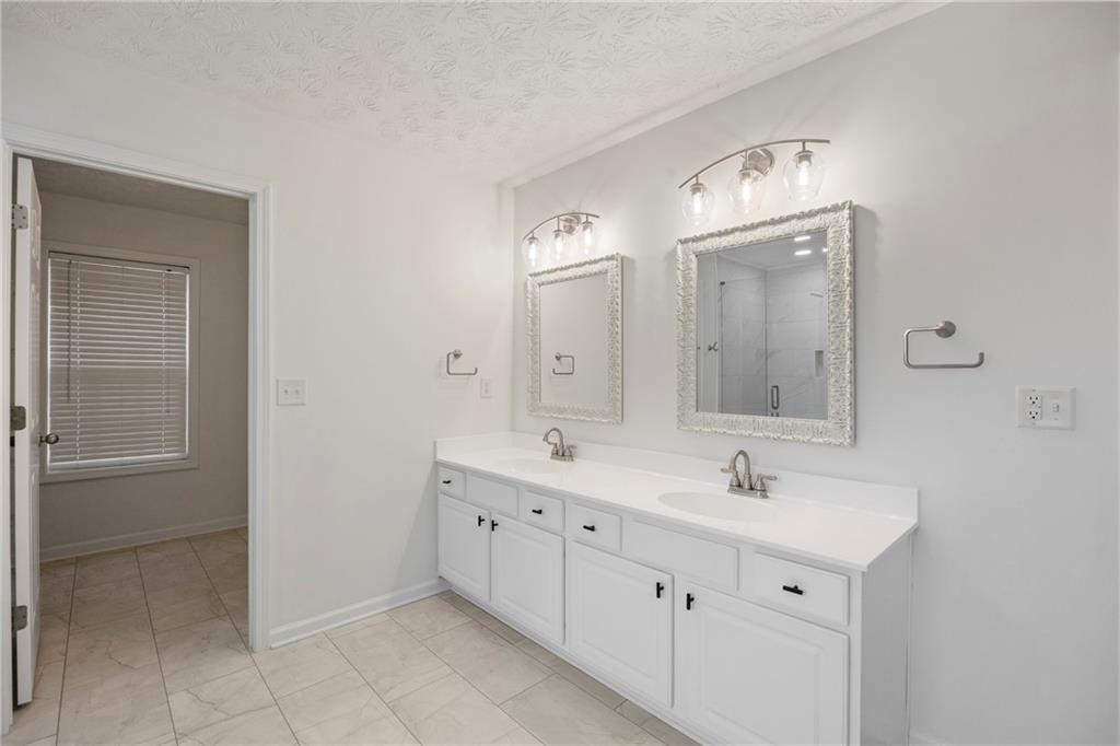 3768 North Sharon Church Road Loganville, GA 30052 - Photo 30 of 58 a spacious bathroom with a double vanity sink mirror and