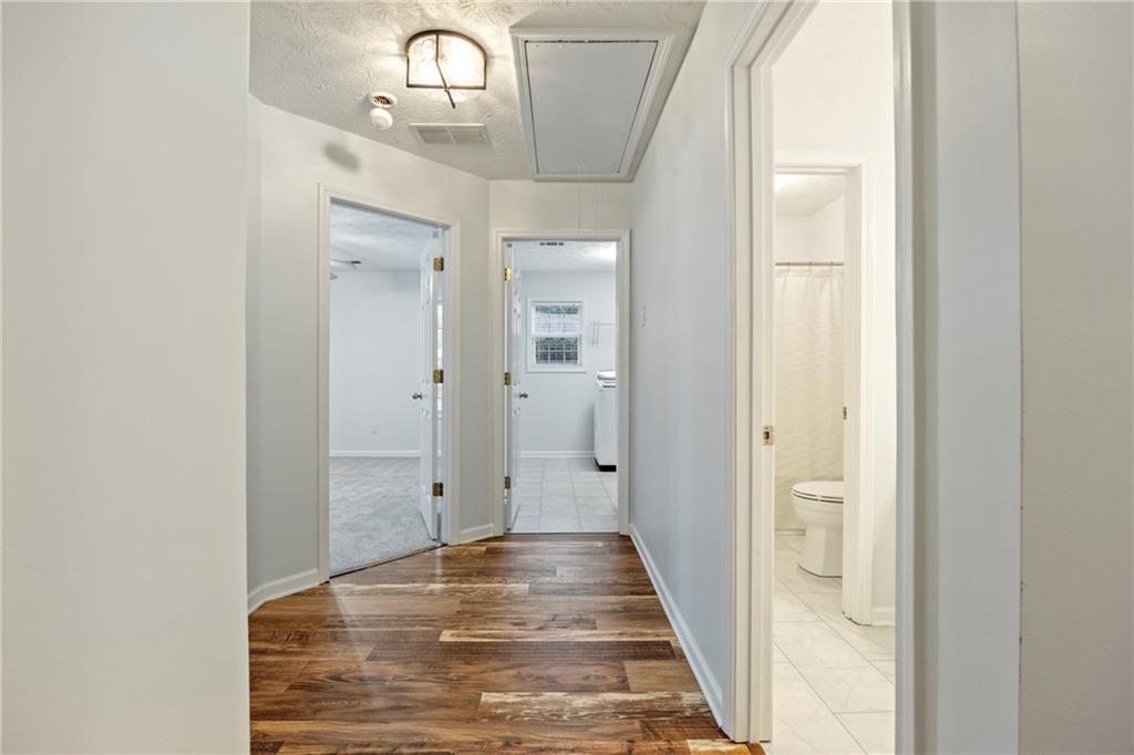 3768 North Sharon Church Road Loganville, GA 30052 - Photo 33 of 58 a view of a hallway with wooden floor and a bathroom