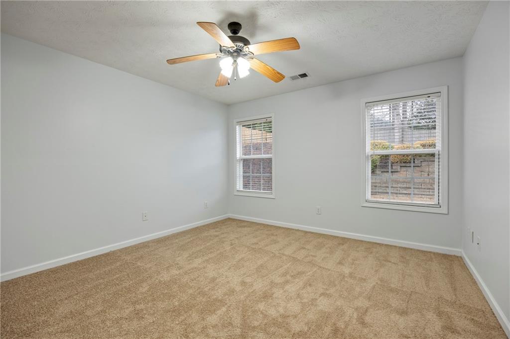 3768 North Sharon Church Road Loganville, GA 30052 - Photo 36 of 58 an empty room with windows and ceiling fan