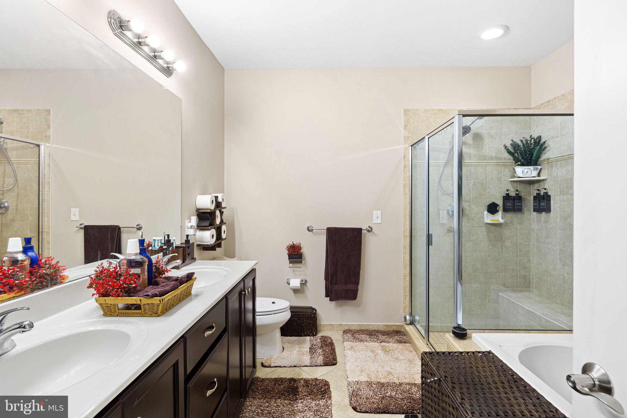 331 Carson Terrace, Unit 331 Huntingdon Valley, PA 19006 - Photo 13 of 15 a bathroom with a double vanity sink mirror and shower