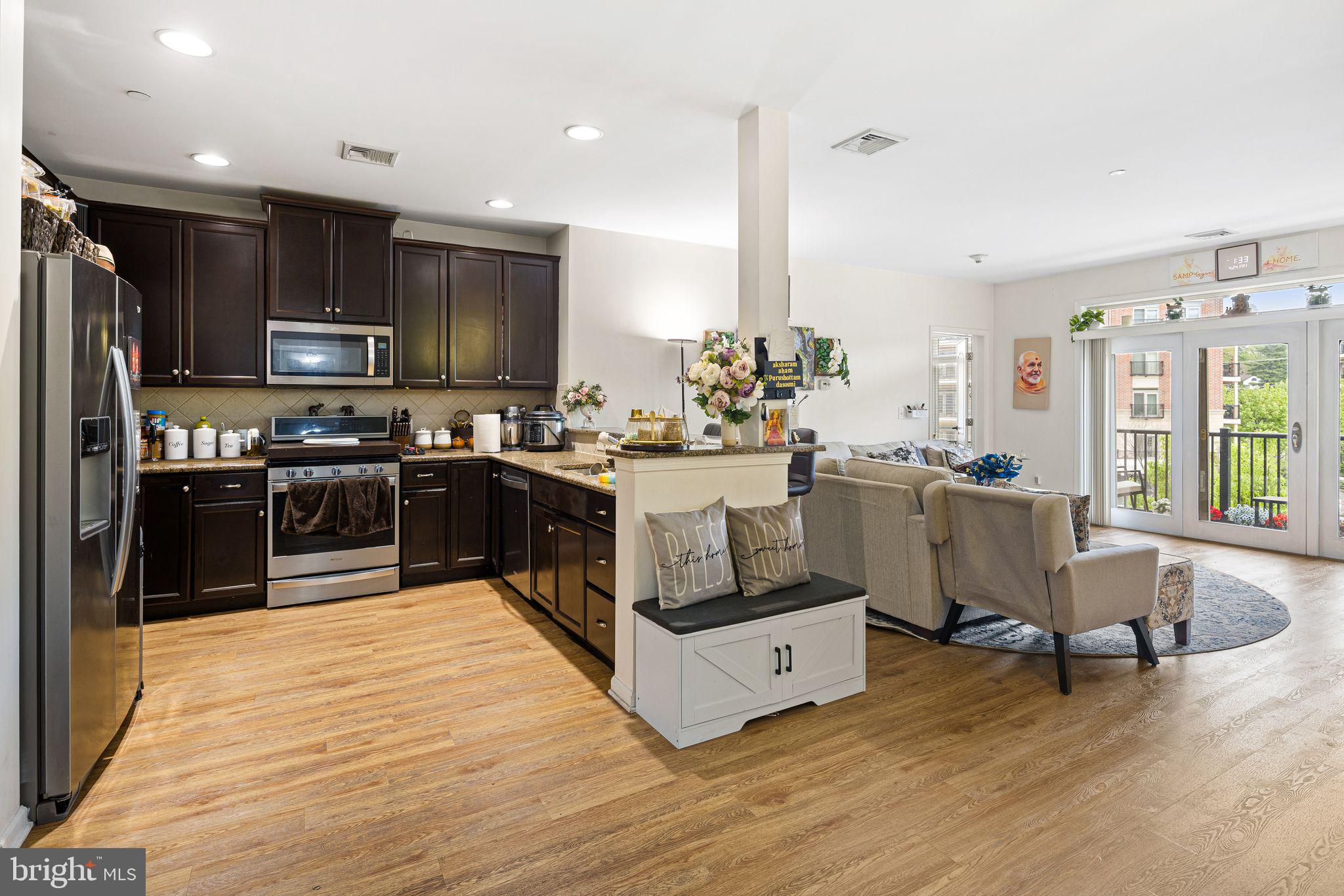 331 Carson Terrace, Unit 331 Huntingdon Valley, PA 19006 - Photo 7 of 15 a kitchen with stainless steel appliances kitchen island granite countertop a stove top oven a sink dishwasher a dining table and chairs