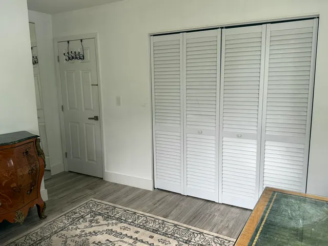 a view of a room with wooden floor and a rug