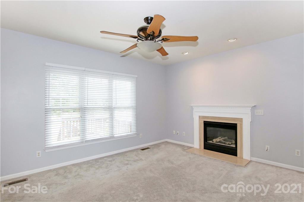 10402 Friarsgate Road Huntersville, NC 28078 - Photo 12 of 46 a view of empty room with fireplace and window