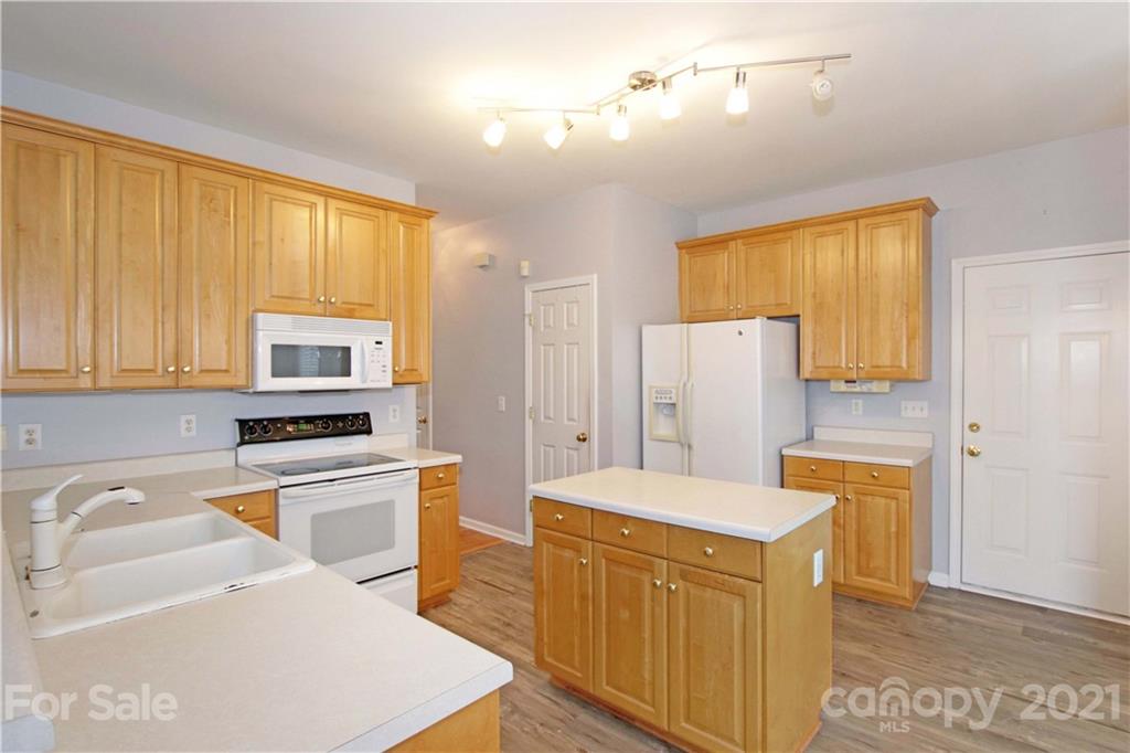 10402 Friarsgate Road Huntersville, NC 28078 - Photo 14 of 46 a kitchen with stainless steel appliances granite countertop a refrigerator a stove top oven a sink dishwasher and white cabinets with wooden floor
