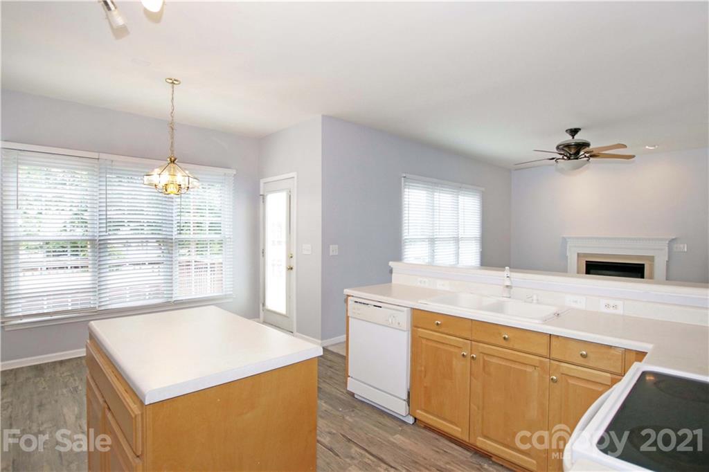 10402 Friarsgate Road Huntersville, NC 28078 - Photo 16 of 46 a kitchen with a stove a sink a chandelier and living room view