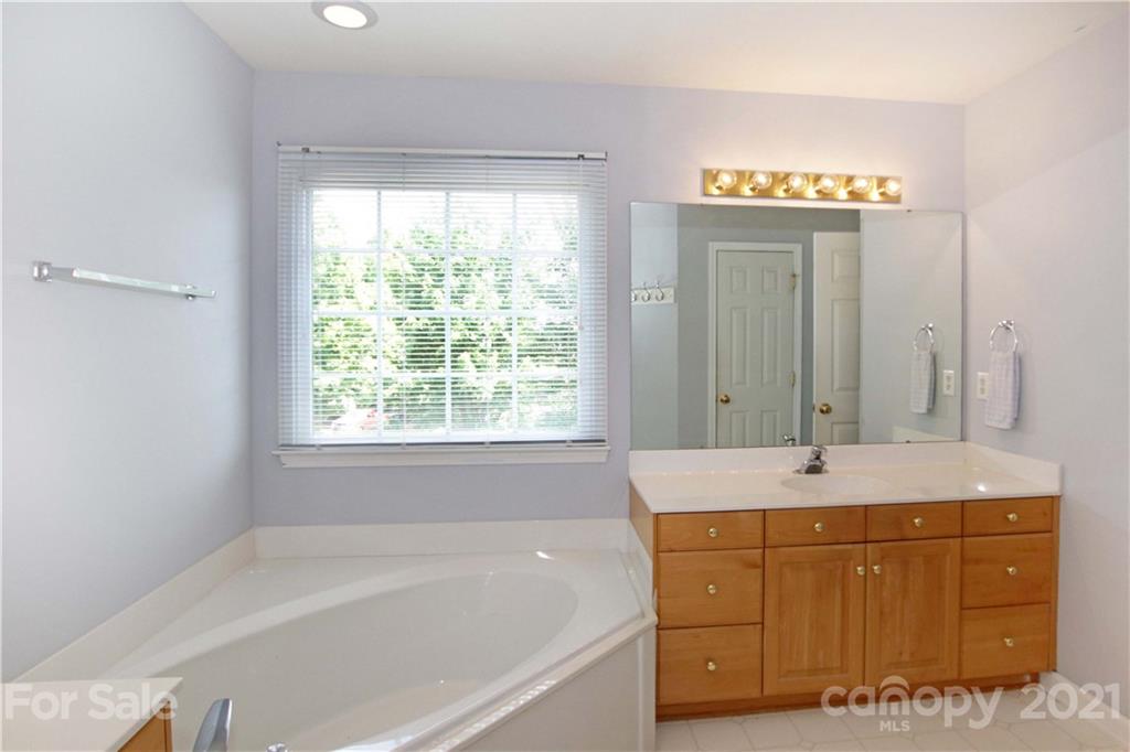 10402 Friarsgate Road Huntersville, NC 28078 - Photo 25 of 46 a spacious bathroom with a tub sink and a mirror