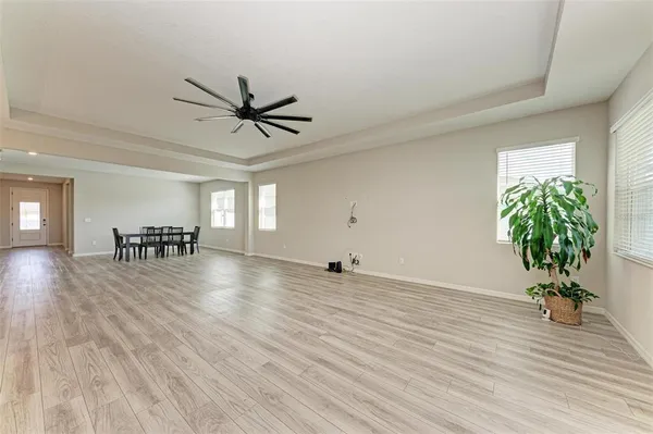 a view of a room with wooden floor and a ceiling fan