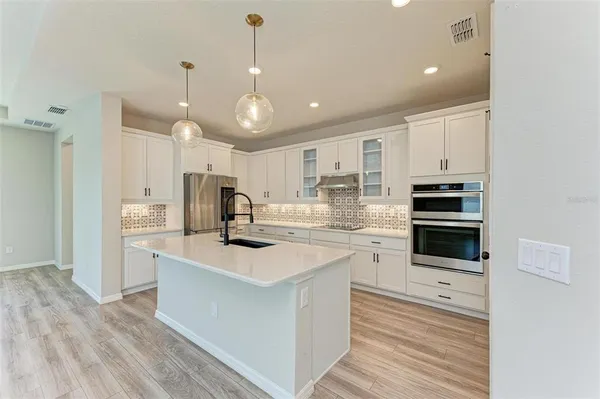 a kitchen with a sink stainless steel appliances and white cabinets