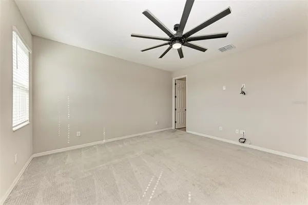 an empty room with a window and a fan