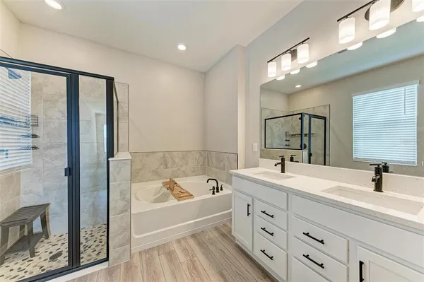 a bathroom with a tub a sink and mirror
