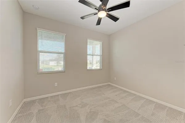 an empty room with a window and a fan