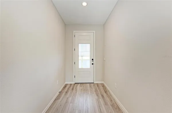 a view of a small space with wooden floor and a window