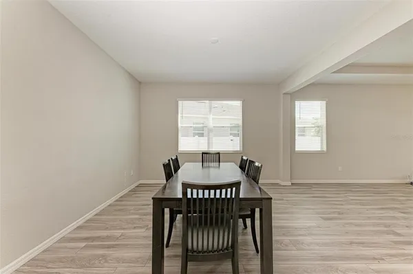 a view of a room with a dining table chairs and wooden floor