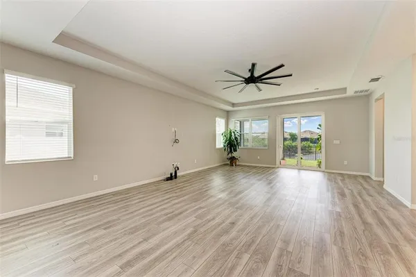 a view of a livingroom with wooden floor and a ceiling fan