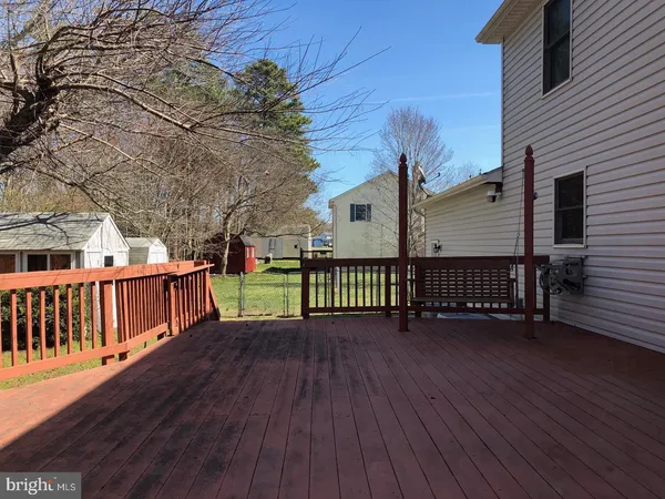 a view of a deck with wooden floor and fence with a large tree
