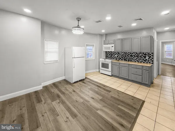 a large kitchen with a stove a sink and a refrigerator